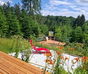 Blick über Taglilien auf Deck und Wiese